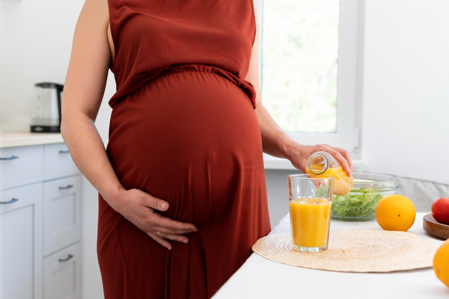Pregnant women pouring juice